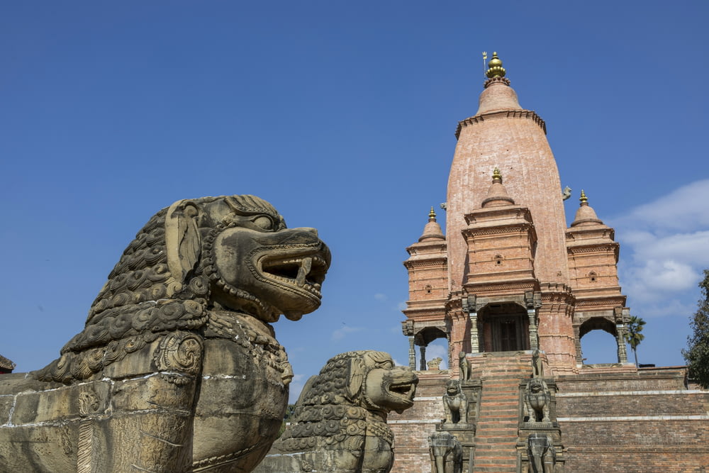 a stone lion statue in front of a building
