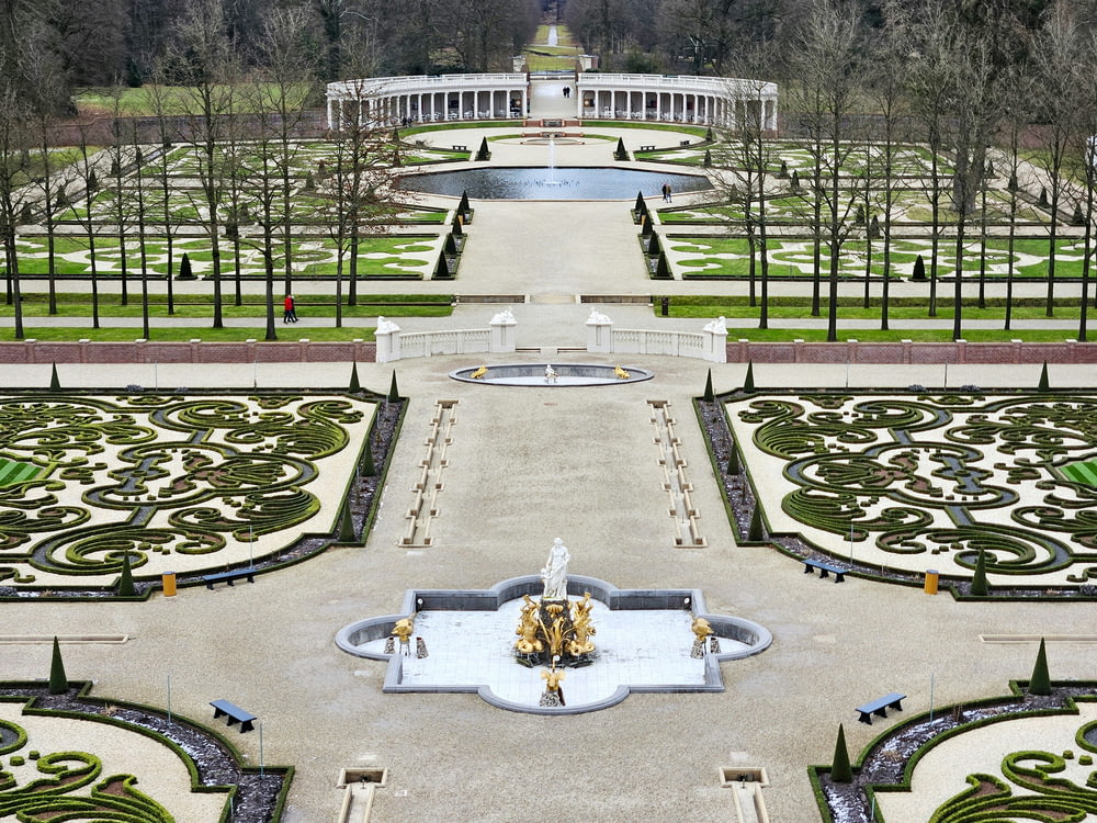 a large garden with a fountain in the middle of it