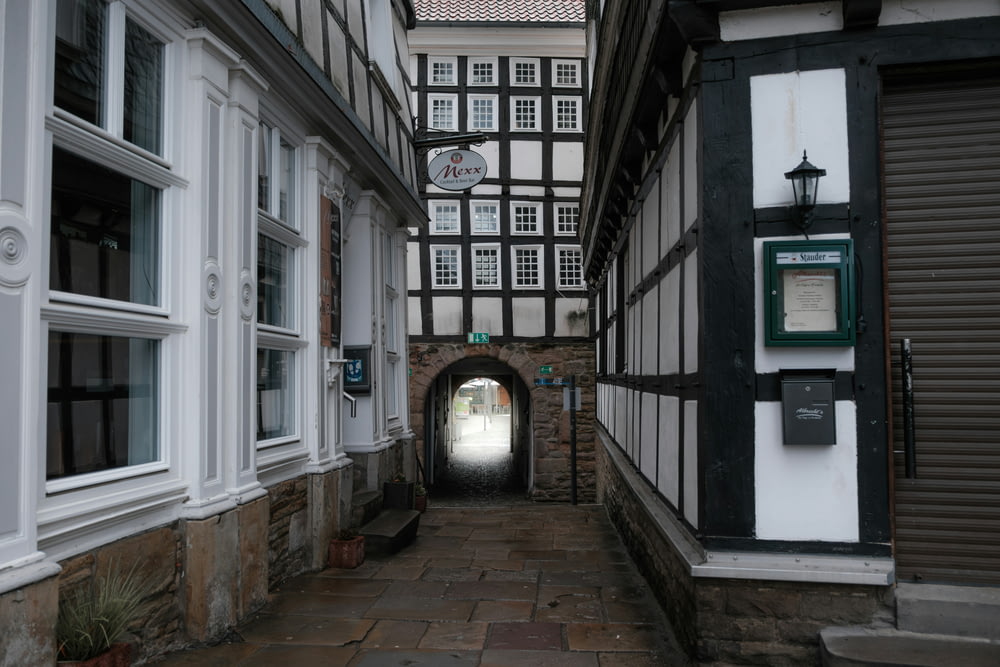 a narrow alley way with a clock tower in the background