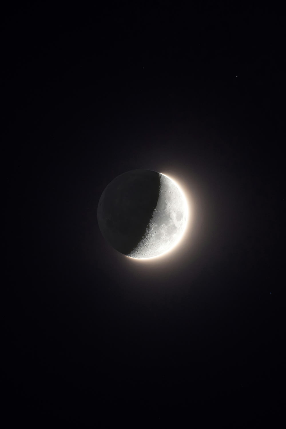 the moon is seen in front of a black background