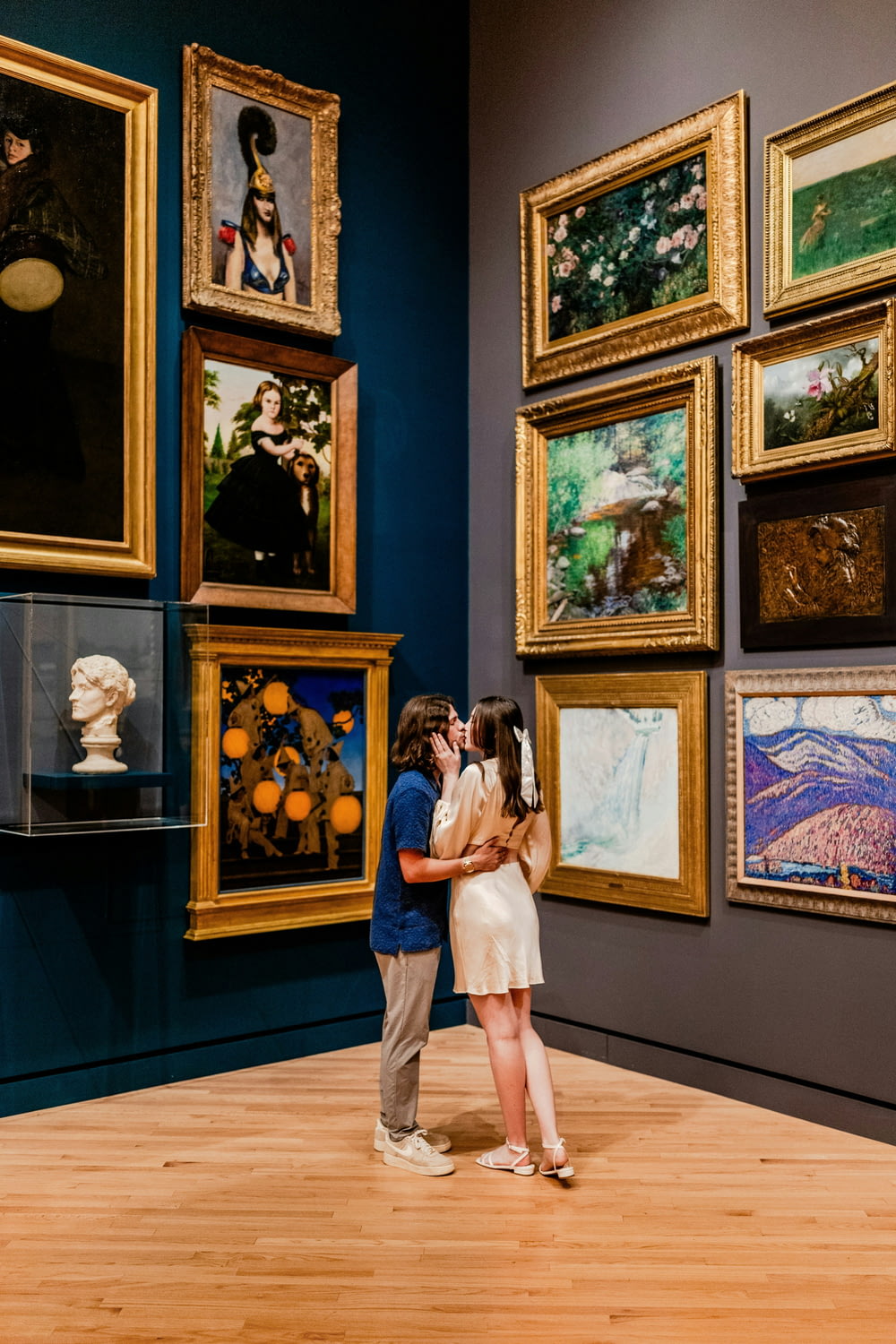 a man and a woman standing in front of paintings