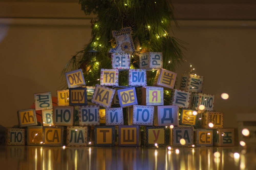 a pile of wooden blocks sitting next to a christmas tree