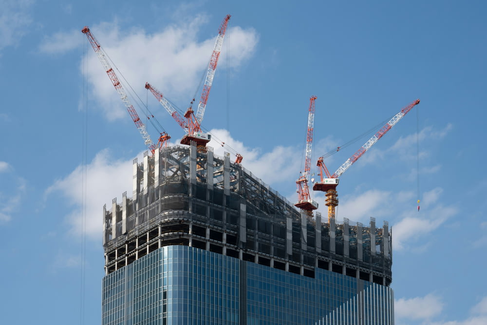 a tall building with cranes on top of it