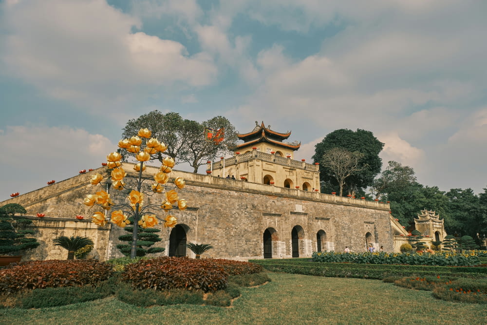 a stone building with a yellow tree in front of it