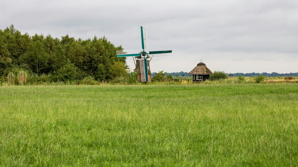 a green field with a windmill in the background