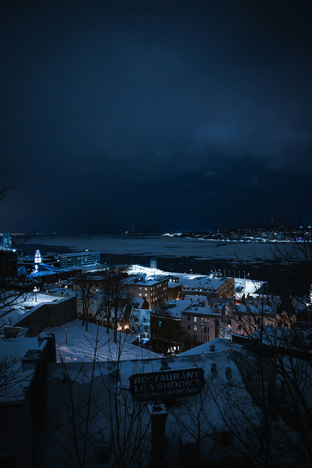 a night view of a city with snow on the ground