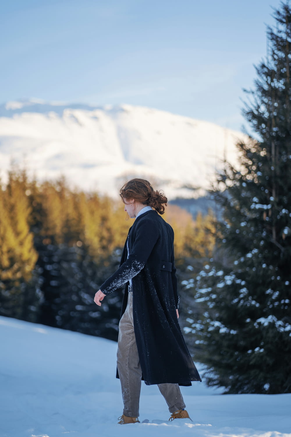 a woman standing in the snow in front of a mountain
