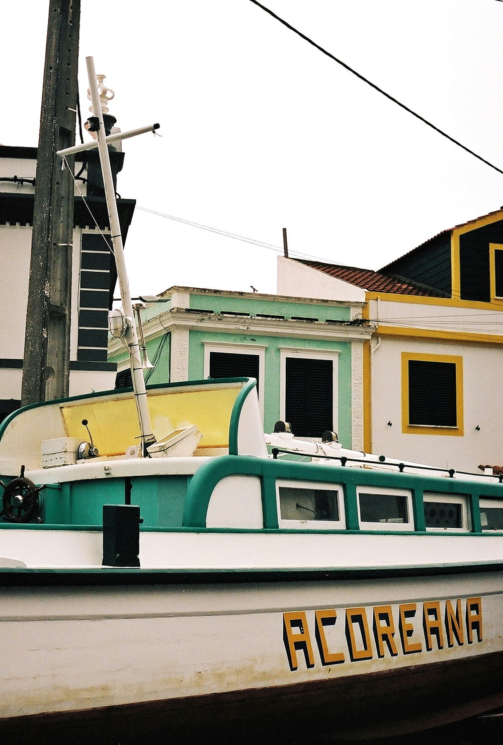 a green and white boat parked in front of a building