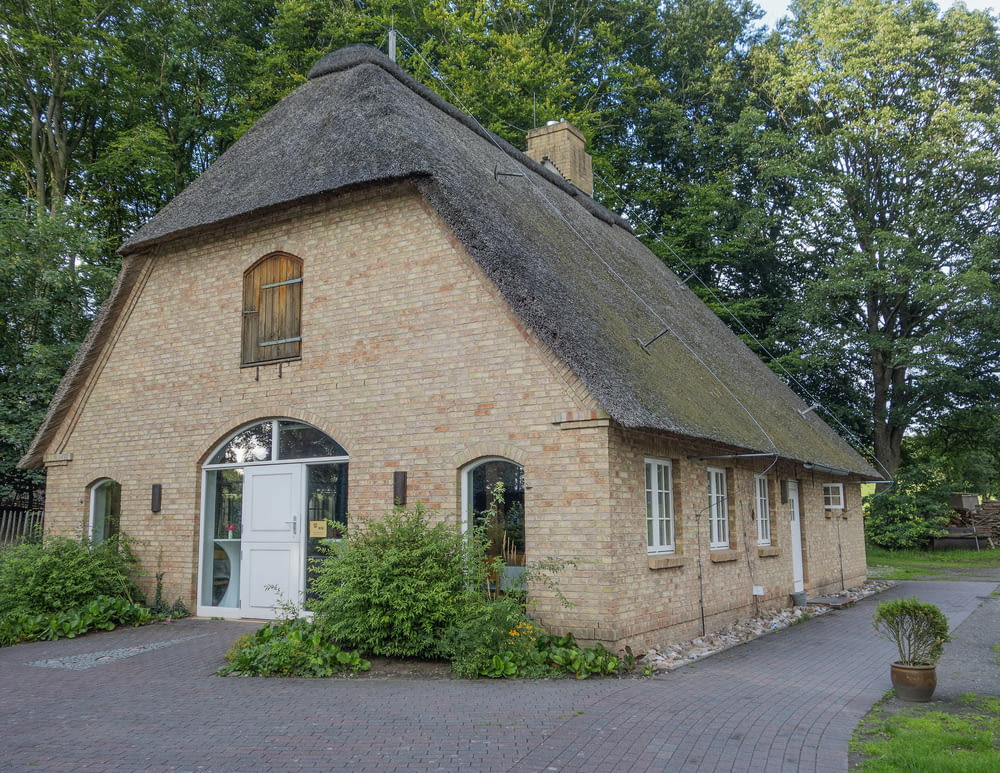 a small brick building with a thatched roof