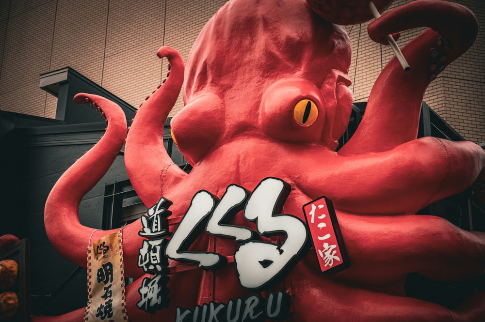 a giant red octopus statue in front of a building