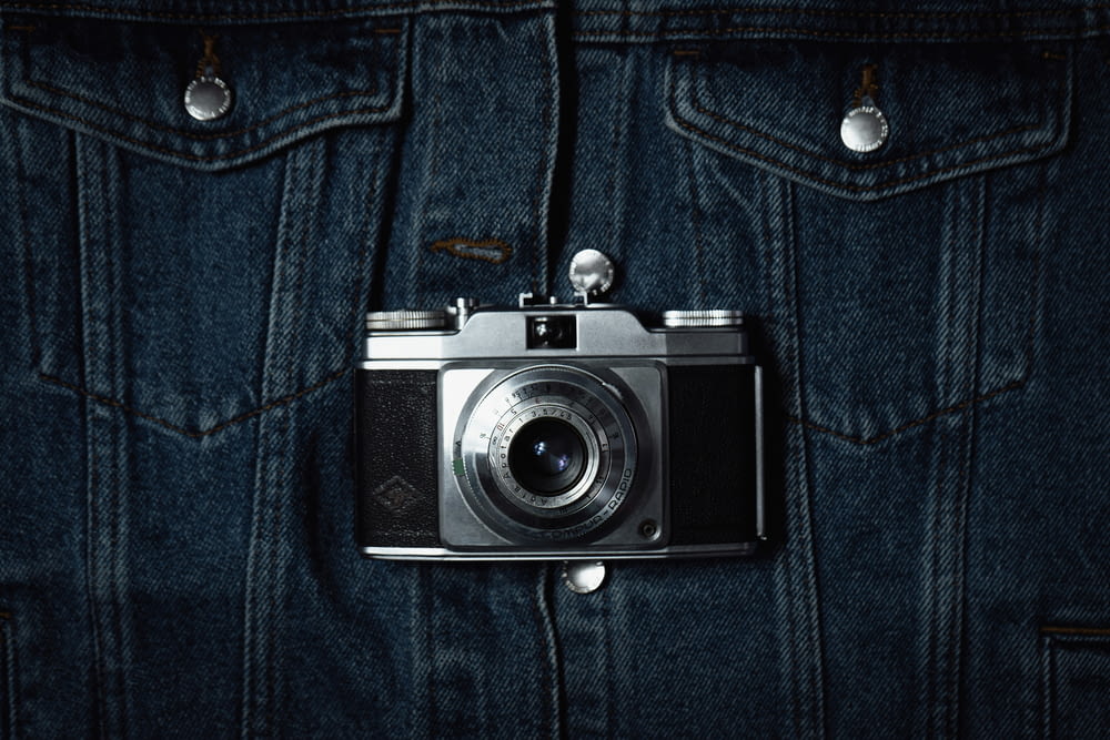 a camera hanging on the back of a jean jacket