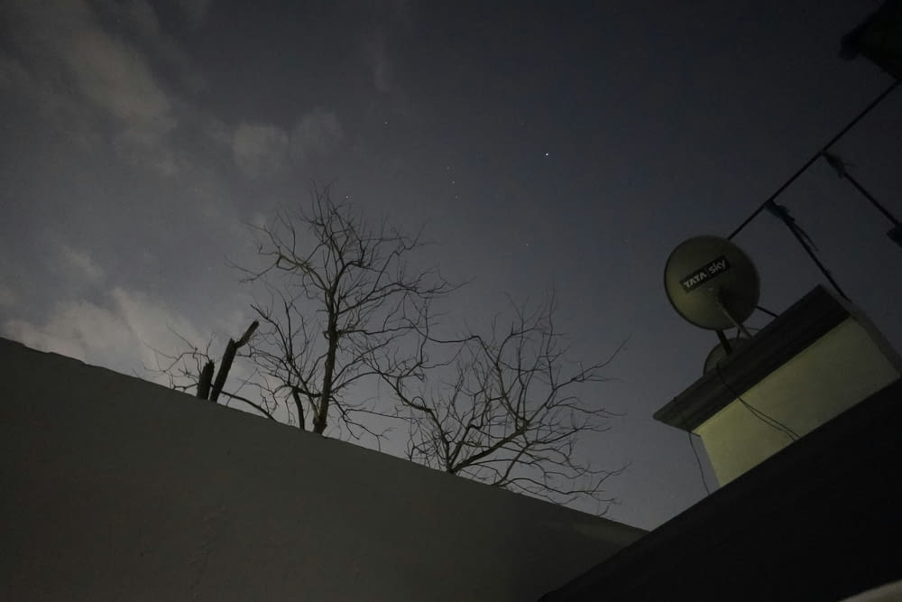 a satellite dish on top of a building at night