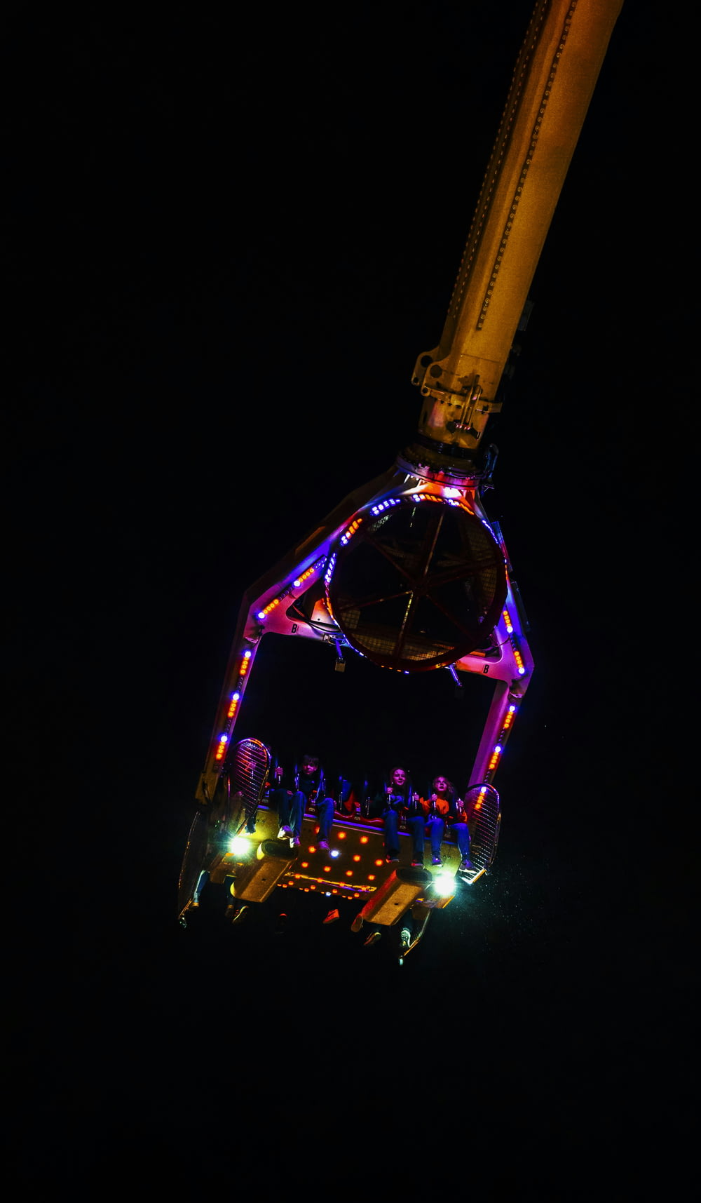 a ferris wheel lit up at night in the dark