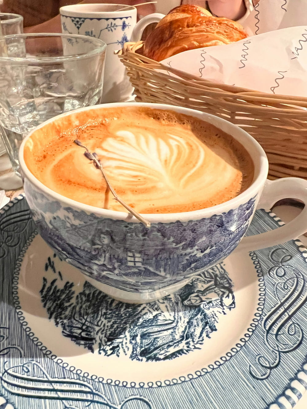 a cup of coffee on a blue and white plate