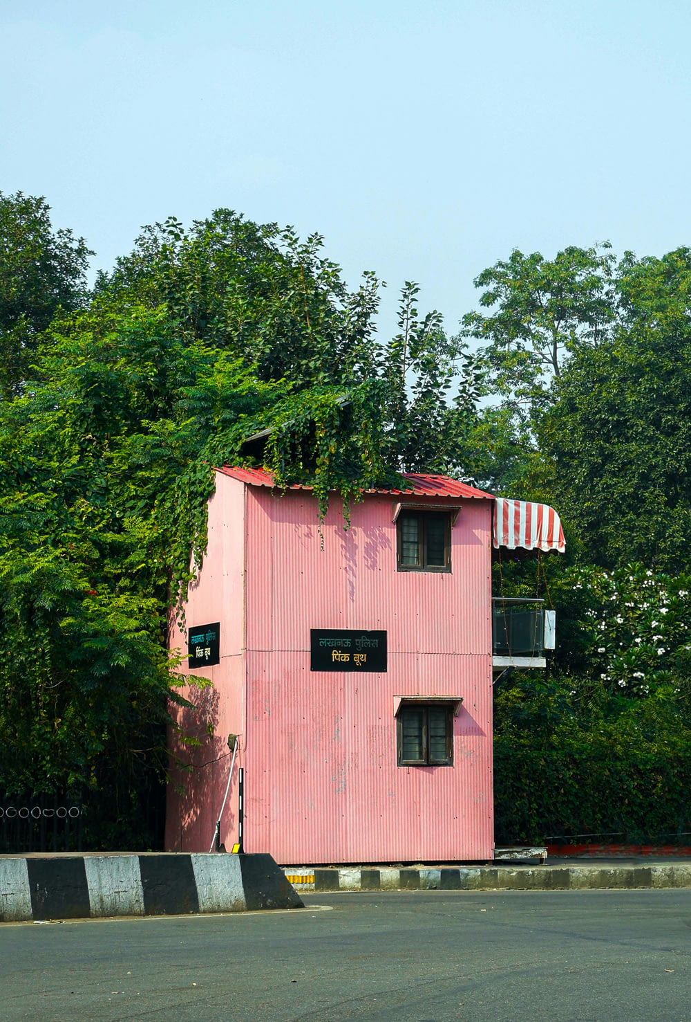 a pink building with a balcony on top of it