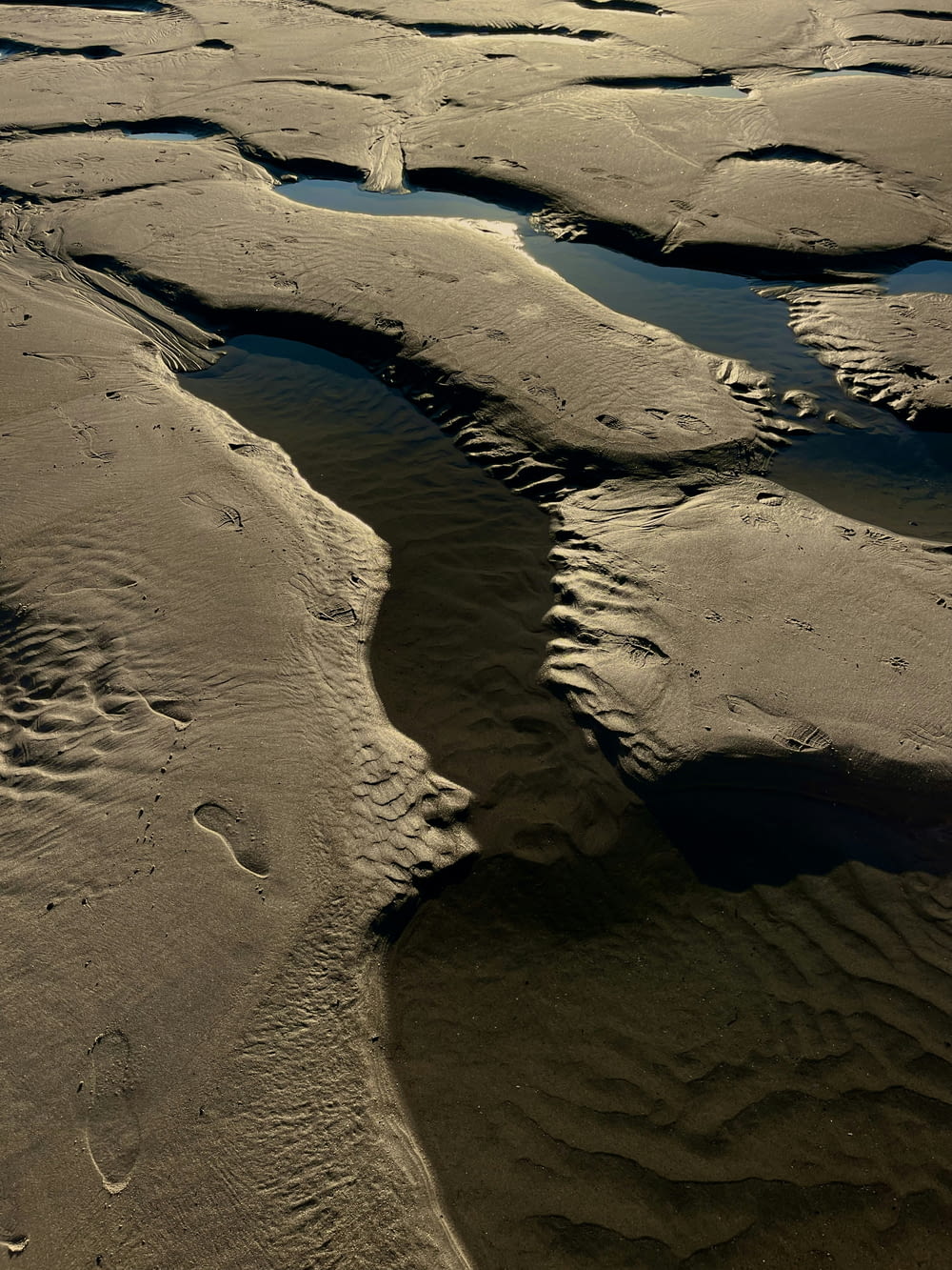an aerial view of a river running through a sandy beach