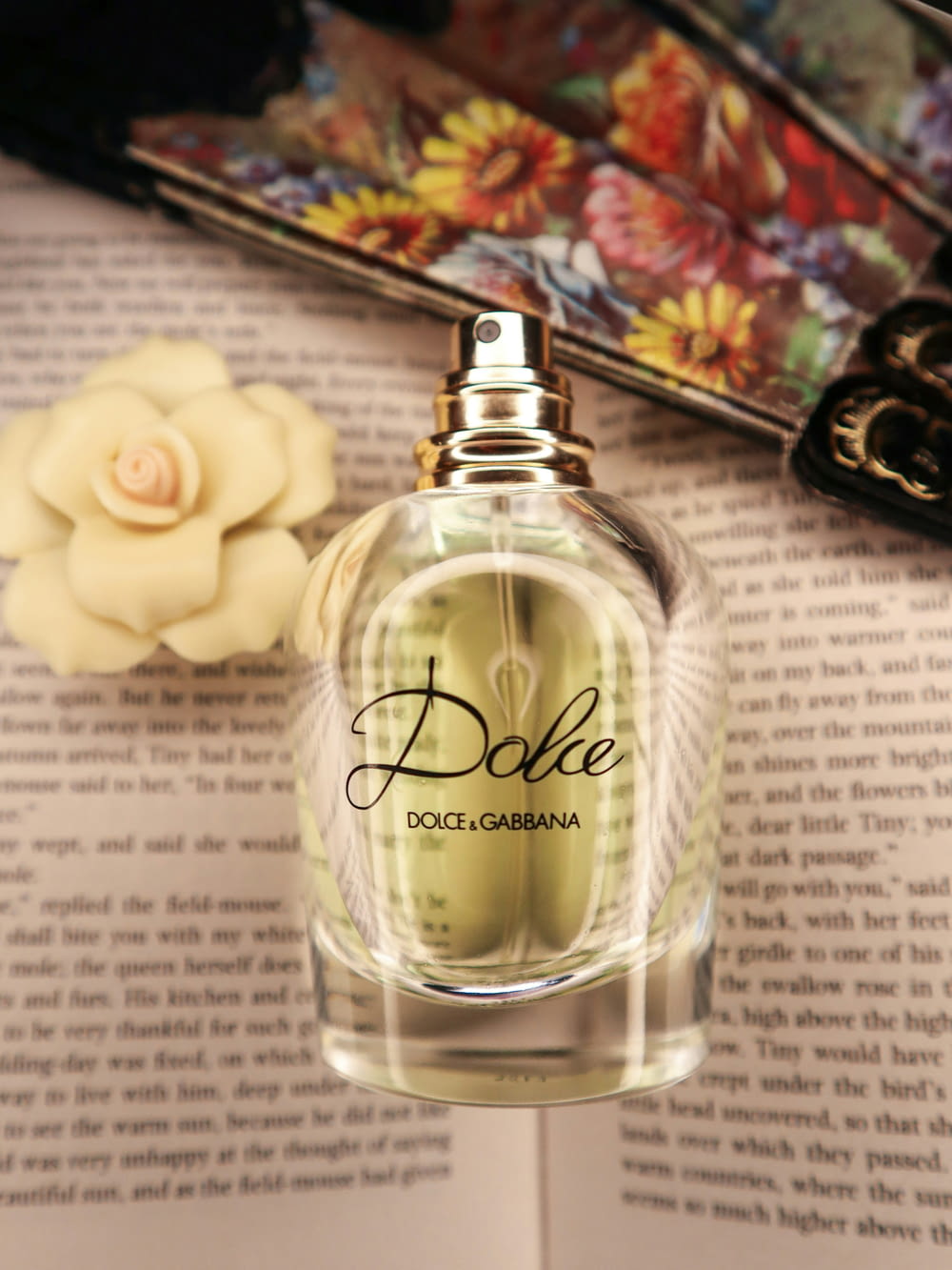 a bottle of dolce perfume sitting on top of a book