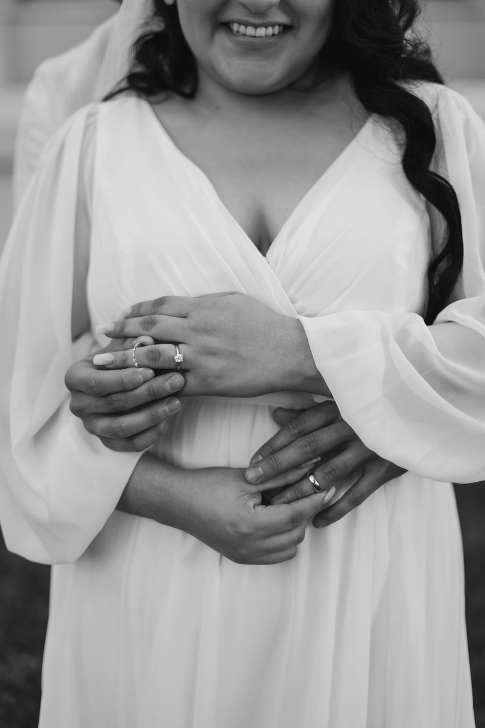 a woman in a white dress holding her hands together