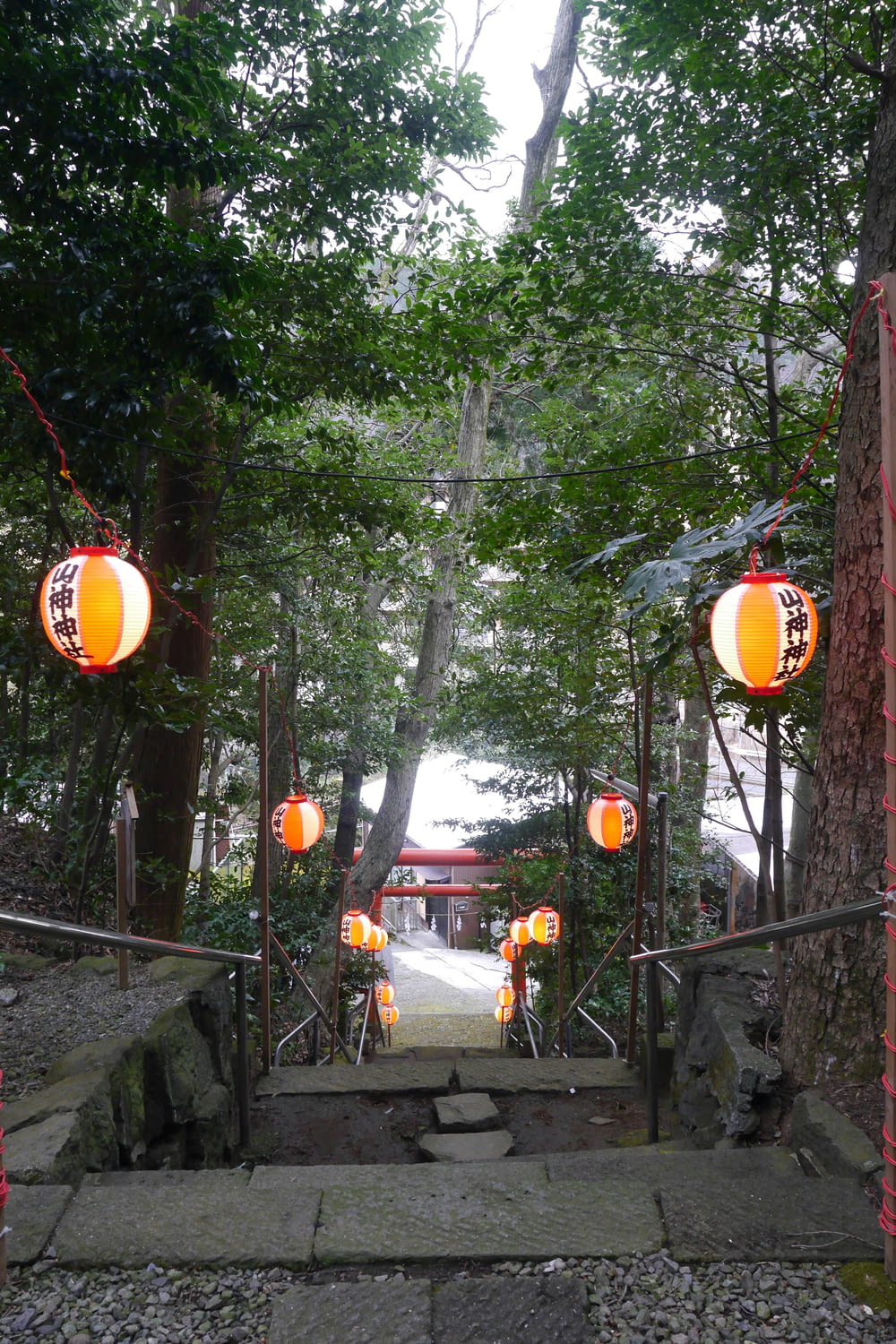 a walkway with lanterns hanging from it's sides
