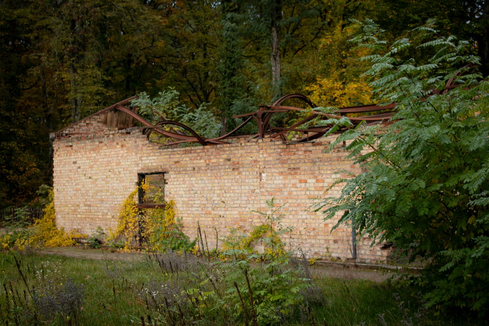 a brick building surrounded by trees and bushes
