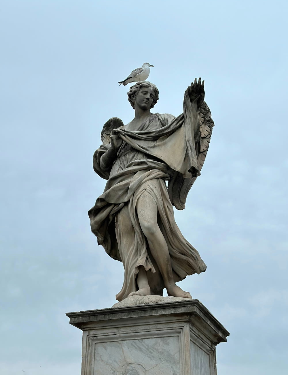 una statua di una donna con un uccello sulla spalla
