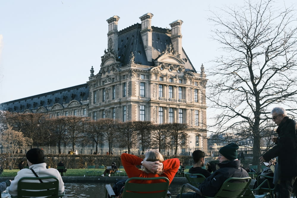 a group of people sitting in lawn chairs in front of a building