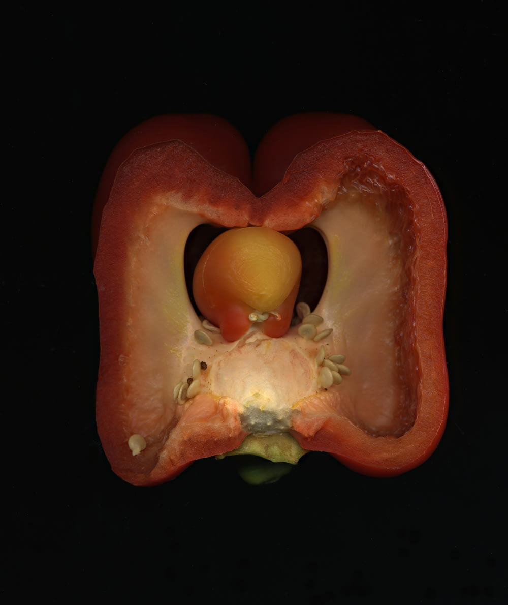 a close up of a red pepper with a black background