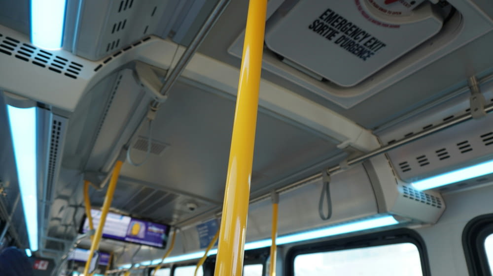 the inside of a bus with yellow poles
