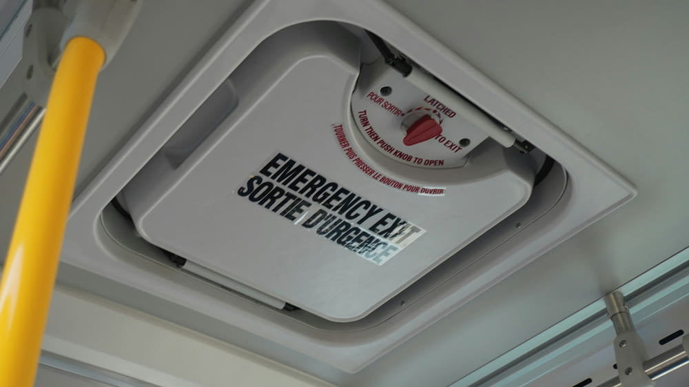 an emergency exit sign mounted to the ceiling of a bus