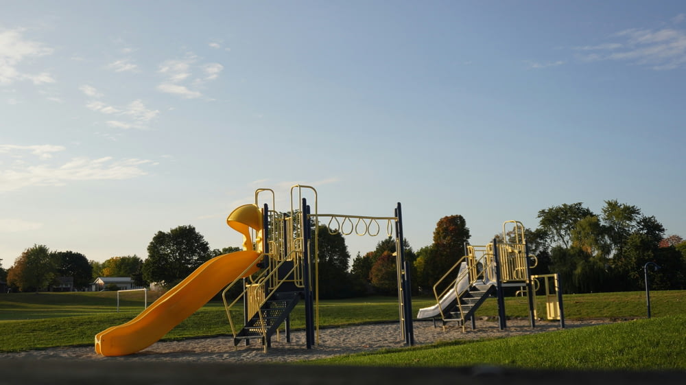 a playground with a yellow slide and a yellow slide