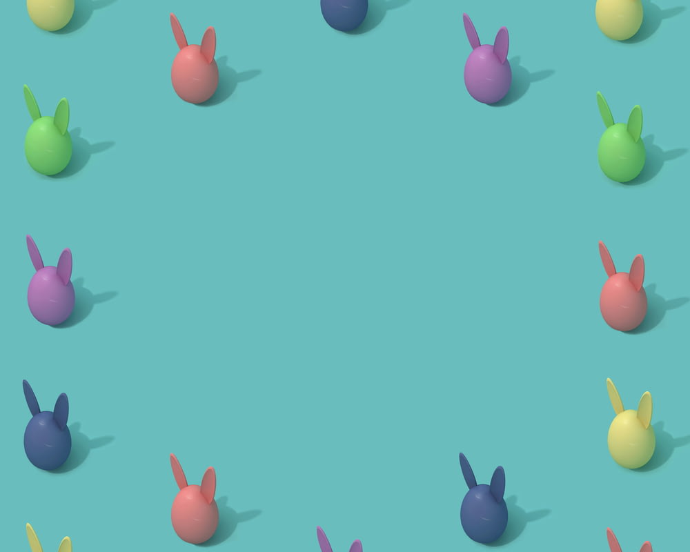um grupo de coelhos de cores diferentes sentados em cima de uma superfície azul