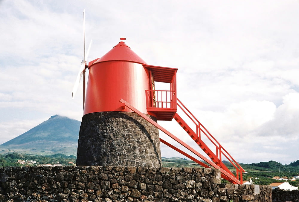 a red tower sitting on top of a stone wall