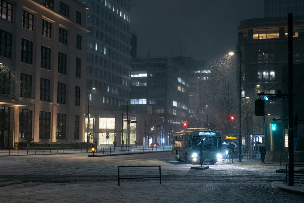 a bus driving down a snowy street at night