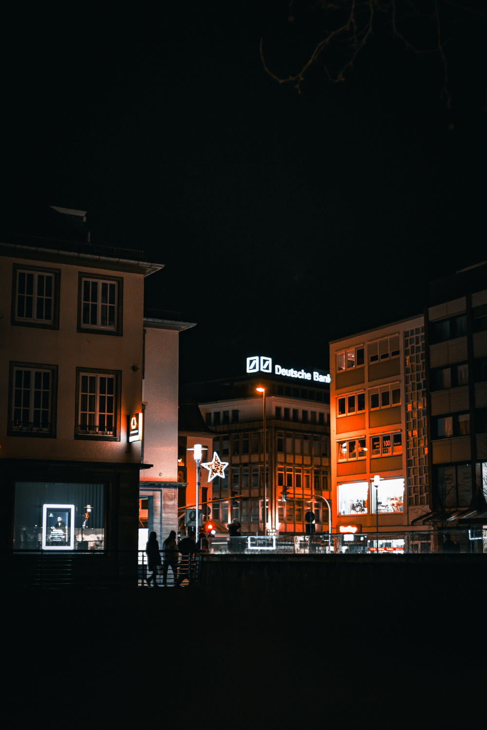 a group of people walking around a city at night