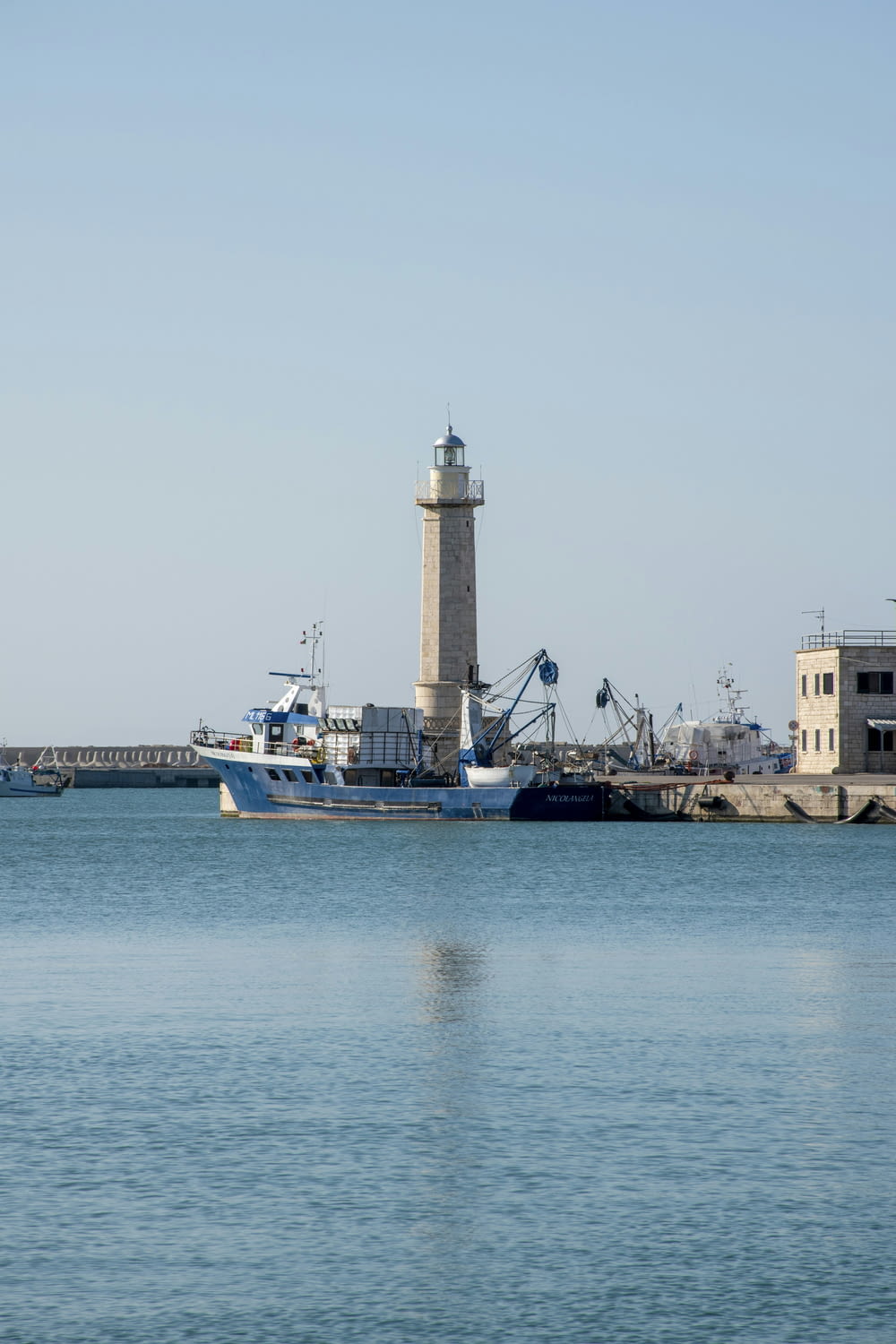 a large body of water with a light house in the background