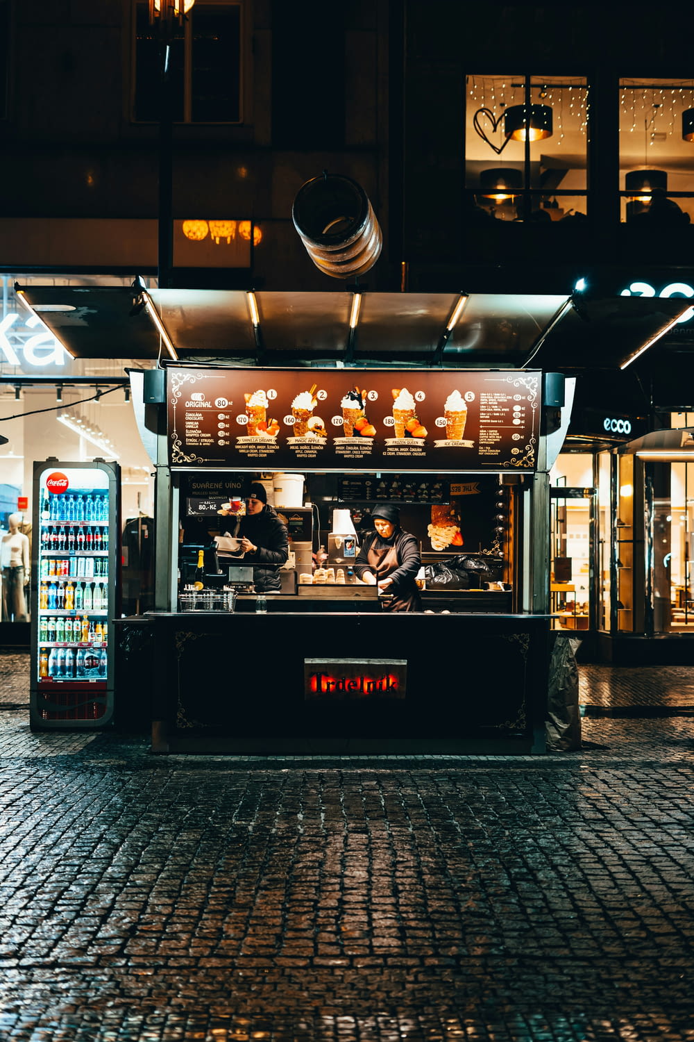 a food stand sitting on the side of a street at night