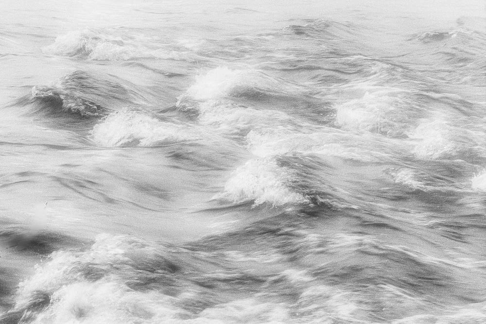 a black and white photo of waves in the ocean
