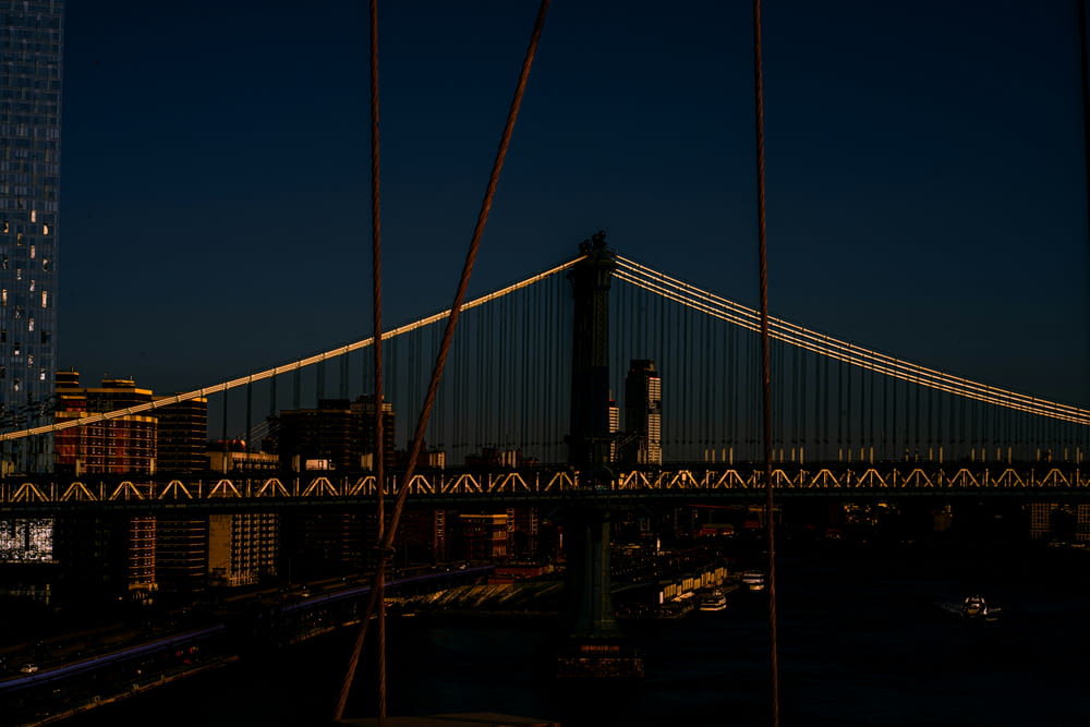 uma vista de uma ponte à noite com uma cidade ao fundo