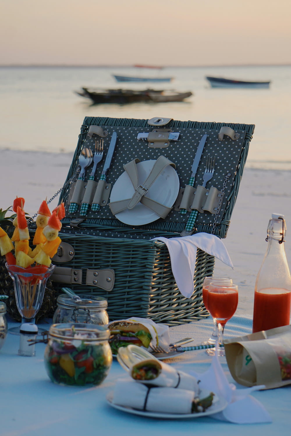 a picnic set up on the beach with food and drinks