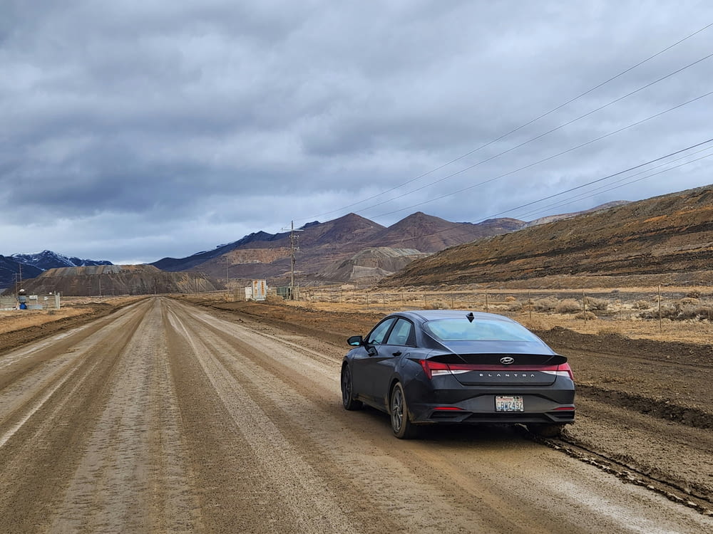 a car parked on a dirt road in the middle of nowhere