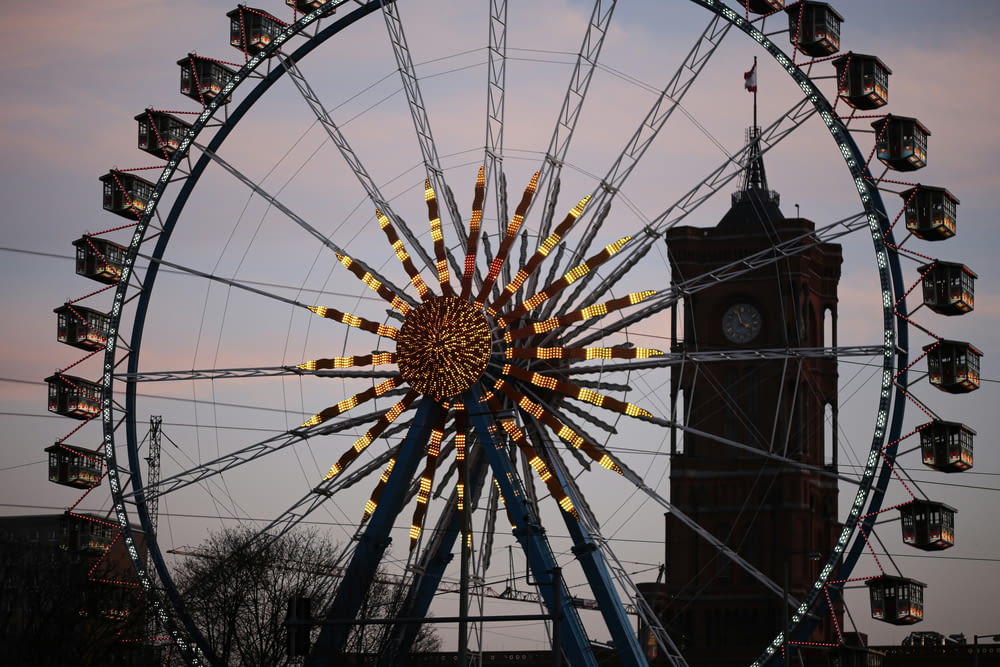 a ferris wheel with a clock tower in the background