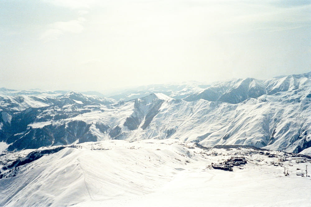 a snow covered mountain with a ski lift in the distance