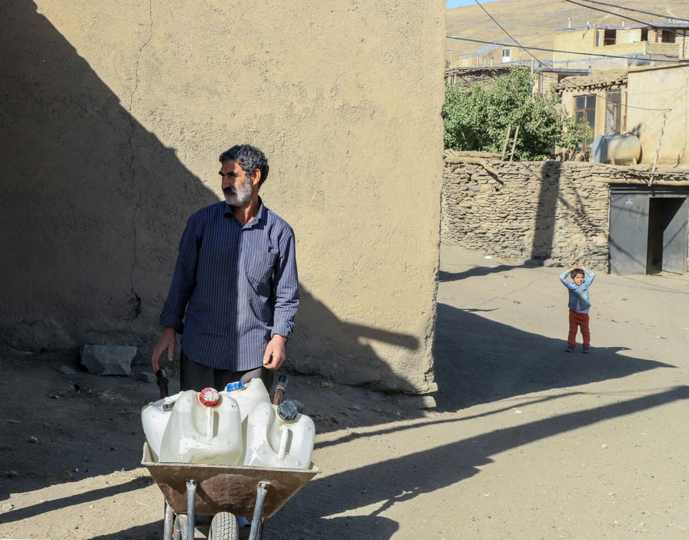 a man pushing a cart filled with jugs of water