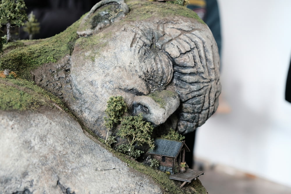 a statue of an elephant with a house in its trunk