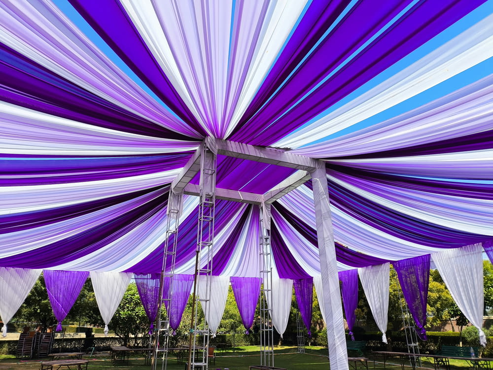 a purple and white canopy with white and blue draping