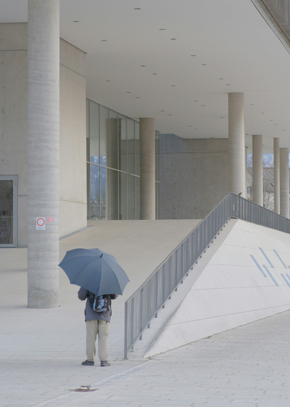 a person with an umbrella standing in front of a building