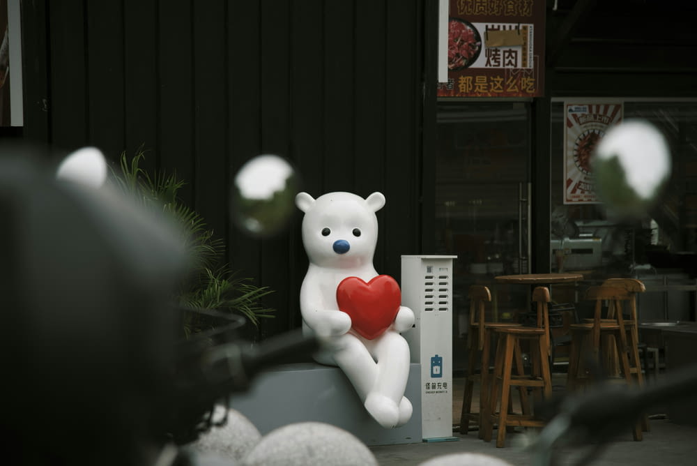 a large white teddy bear holding a red heart