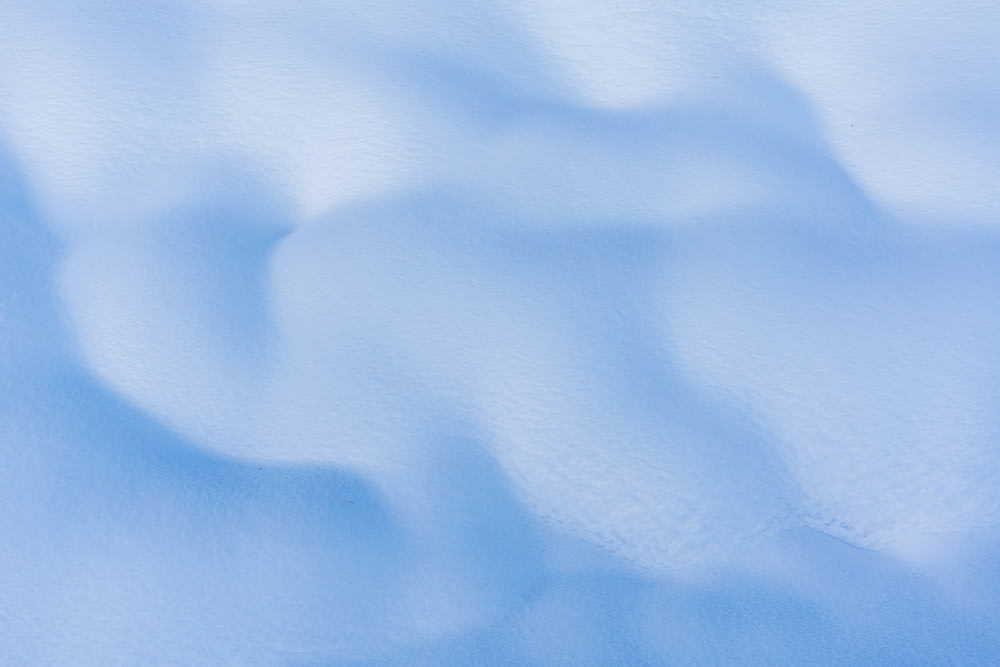 a snow covered ground with a blue sky in the background