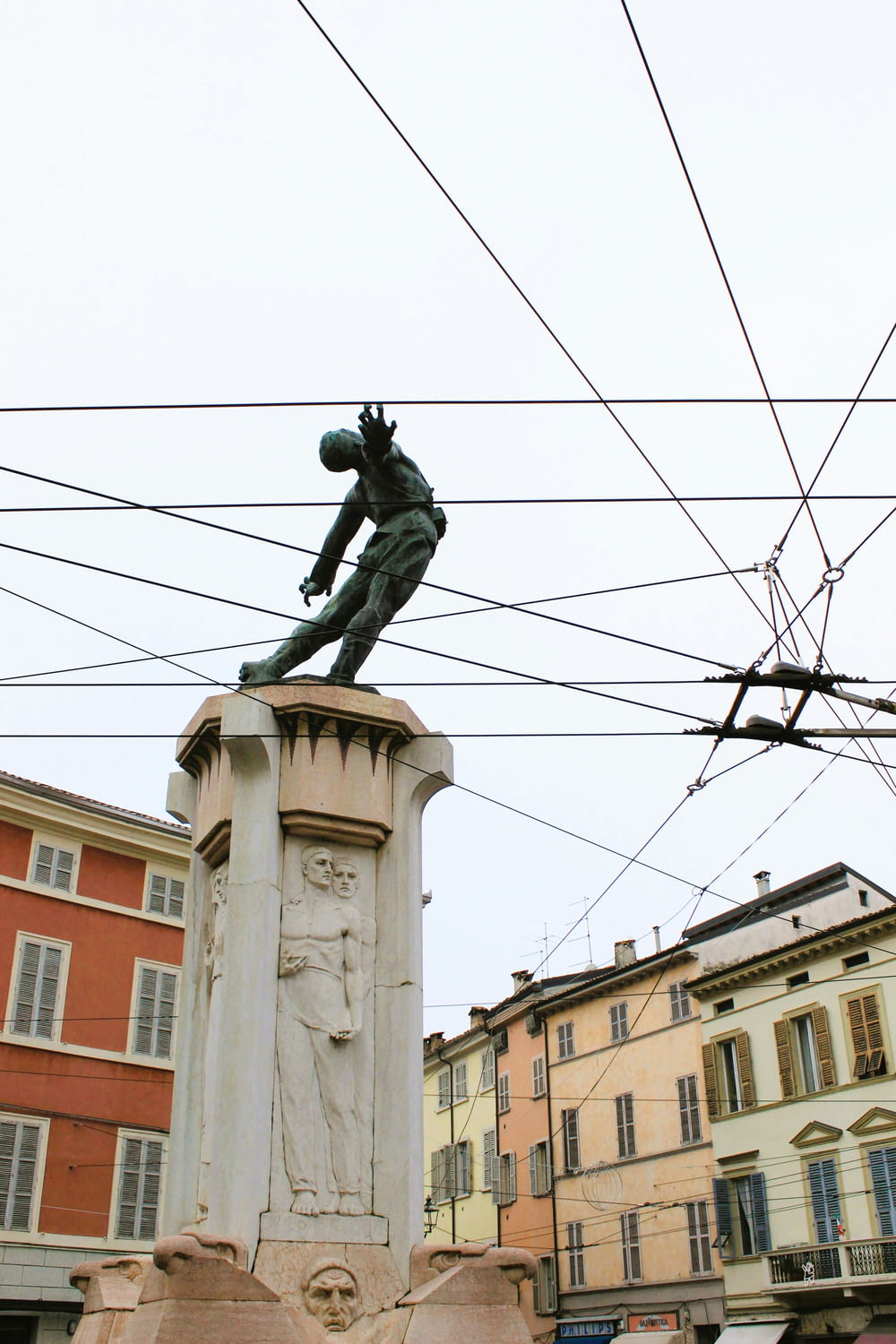 uma estátua de um homem em um pedestal em uma cidade