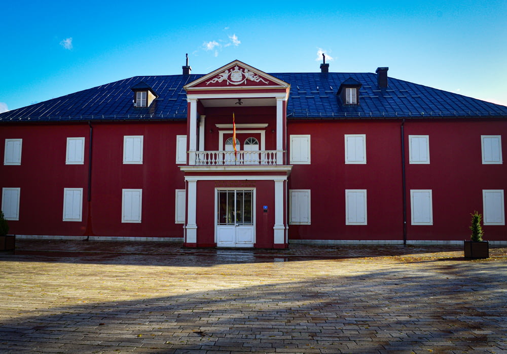 a red building with white windows and a blue roof